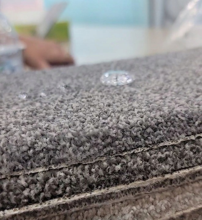 Kropla wody na szarej wykładzinie zabezpieczonej impregnatem NANOTEX do dywanów